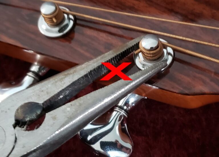 Incorrect way of tightening tuning machines by using needle nose pliers.