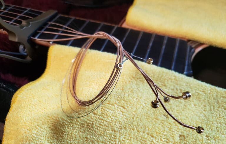 Acoustic guitar strings gathered with capo to keep from scratcing body